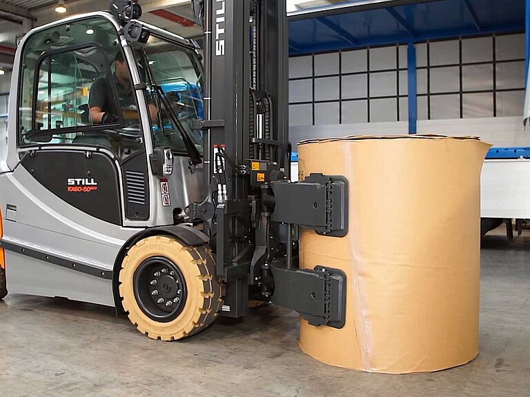 Ein Gabelstapler transportiert einen Ballen mithilfe einer KAUP-Rollenklammer durch ein Lager