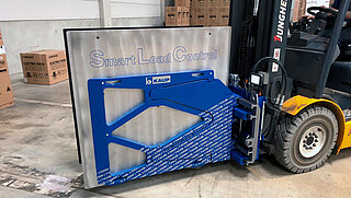 Blue forklift clamp with metal plate on the inside and the inscription "Smart Load Control"