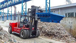 Les déchets de papier lourds sont transportés à l’aide du positionneur rotatif de fourches 15T456.