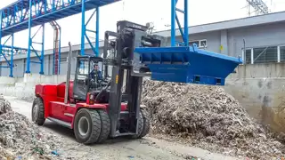 Heavy bales of paper rubbish are transported with the rotating Fork Positioner 15T456.
