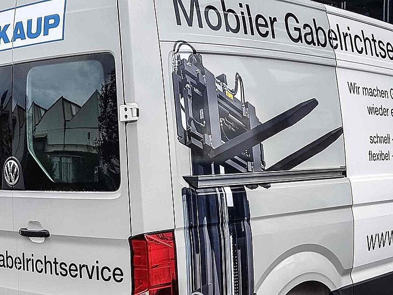 Ein silberner Transporter von KAUP mit der Aufschrift "Mobiler Gabelrichtservice"