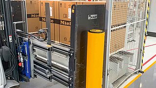 Nahaufnahme eines Smart Load Control Anbaugeräts bei der Aufnahme mehrerer verpackter Waschmaschinen