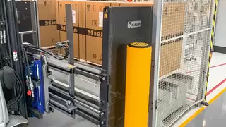 Nahaufnahme eines Smart Load Control Anbaugeräts bei der Aufnahme mehrerer verpackter Waschmaschinen