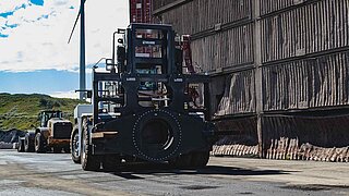 Eine große schwarze Baumaschine, ausgerüstet mit einem speziellen drehbaren Anbaugerät