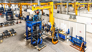 Mehrere Mitarbeiter überwachen die Herstellung von Anbaugeräten in einer Fabrikanlage von KAUP