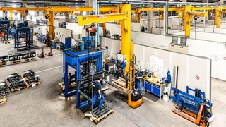 Mehrere Mitarbeiter überwachen die Herstellung von Anbaugeräten in einer Fabrikanlage von KAUP