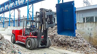 Les déchets de papier lourds sont transportés à l’aide du positionneur rotatif de fourches 15T456.