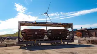 Zwei Schlackecontainer in einem Container ohne Wände vor einem Industriegebiet