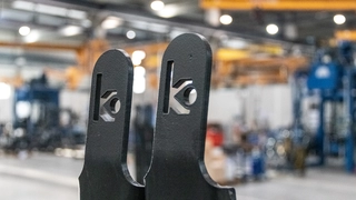 Nahansicht der Spitzen einer schwarz beschichteten Gabelstaplergabel mit eingestanztem KAUP Logo