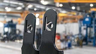 Nahansicht der Spitzen einer schwarz beschichteten Gabelstaplergabel mit eingestanztem KAUP Logo