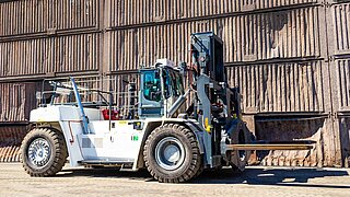 Eine große Baumaschine mit speziellem, drehbaren Anbaugerät auf einem Abbaugelände