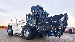 Machine de chantier blanche avec accessoire rotatif et bac intégré pour les déchets de construction