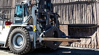 Eine große schwarze Baumaschine, ausgerüstet mit einem speziellen drehbaren Anbaugerät