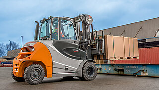 Une machine de construction équipée d'un chariot élévateur lors du transport d'un grand paquet