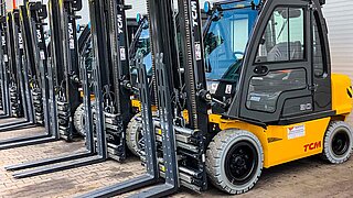 Construction machines with identical attachments are lined up next to each other