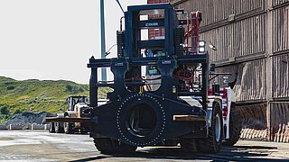 Frontansicht einer großen Baumaschine auf einem Abbaugelände mit einem speziellen Anbaugerät