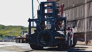 Vista frontal de una gran máquina de construcción en una cantera con un accesorio especial