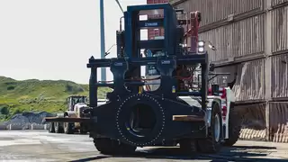 Frontansicht einer großen Baumaschine auf einem Abbaugelände mit einem speziellen Anbaugerät