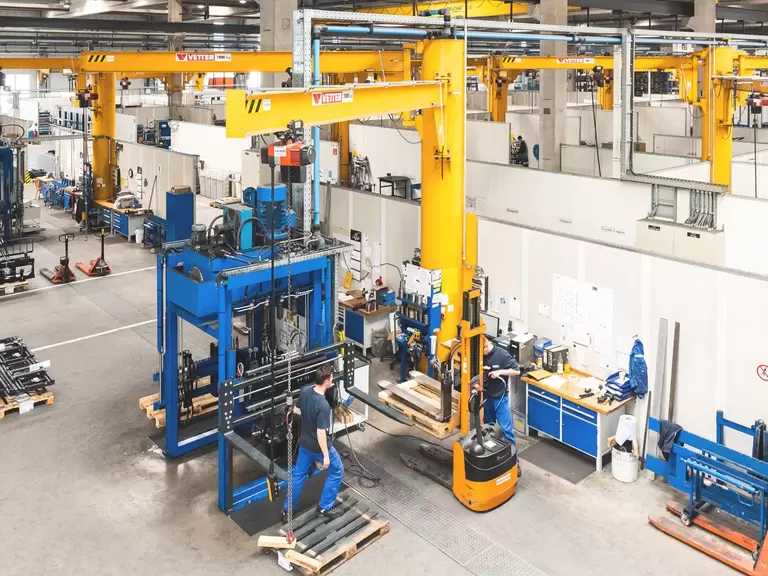 Mehrere Mitarbeiter überwachen die Herstellung von Anbaugeräten in einer Fabrikanlage von KAUP