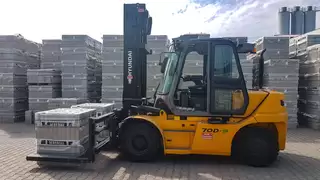 A construction machine with special attachment transporting several stone packs