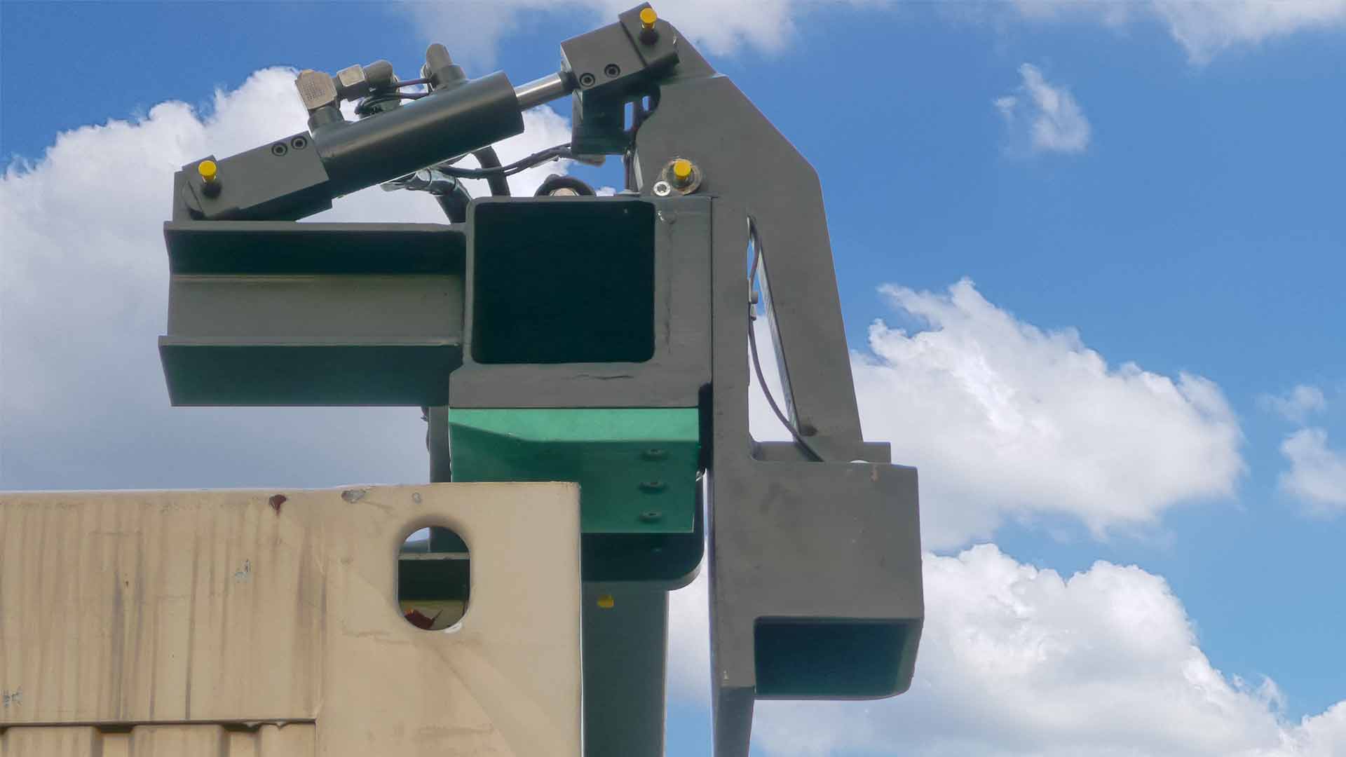 The outer angle of a top spreader attaches to the top corner of a container for transport