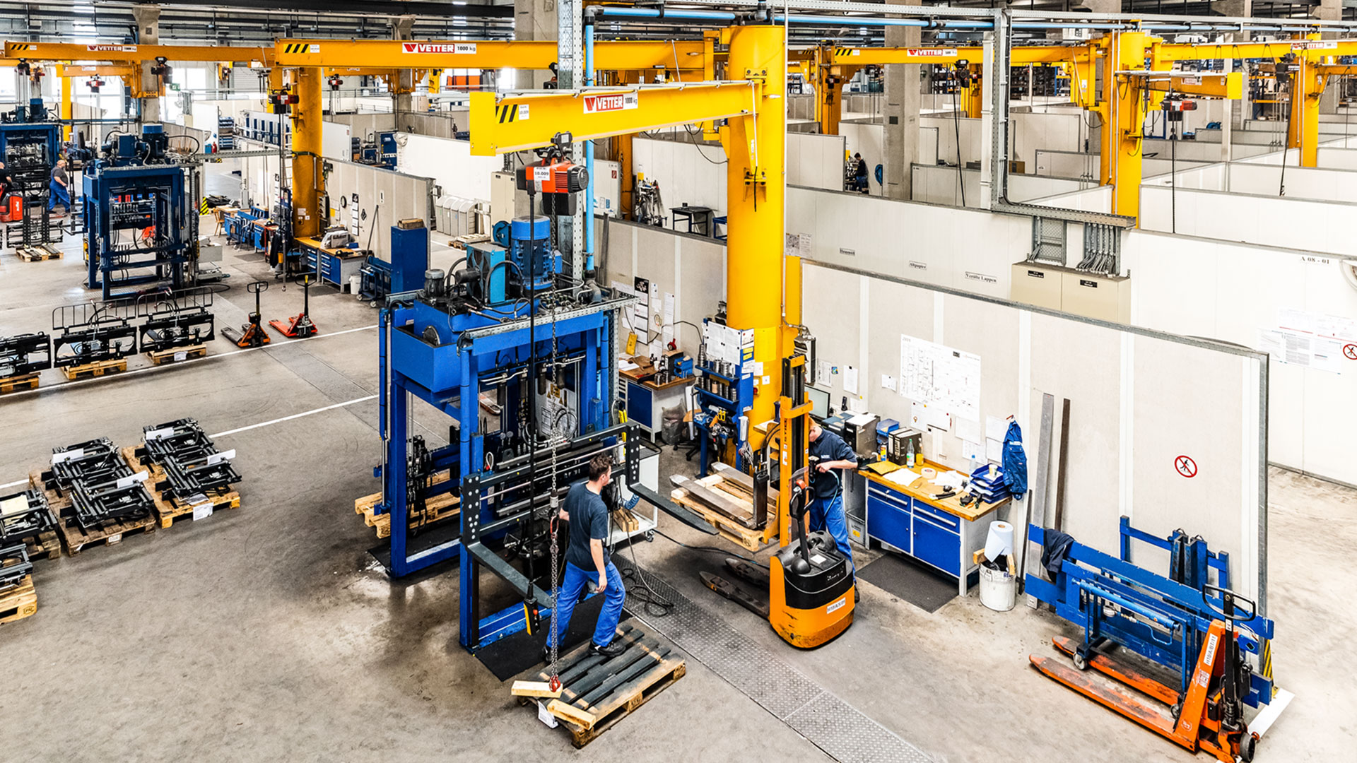 Mehrere Mitarbeiter überwachen die Herstellung von Anbaugeräten in einer Fabrikanlage von KAUP
