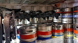 A container is loaded with packed beer kegs by a special fork lift truck attachment