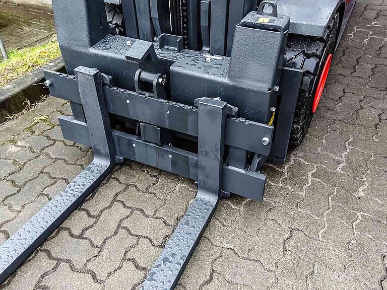 Detailed view of the attachment of an attachment for forklift trucks with raindrops