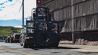 A large black construction machine equipped with a special rotating attachment
