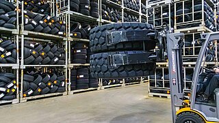 A forklift truck lifts two tyres on top of each other with a double tyre clamp