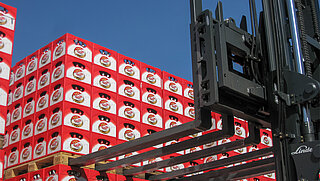 Un accesorio con seis púas recoge palés de cajas de bebidas apiladas en altura