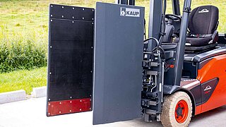 Red forklift truck with mounted Smart Load Control attachment without driver in side view